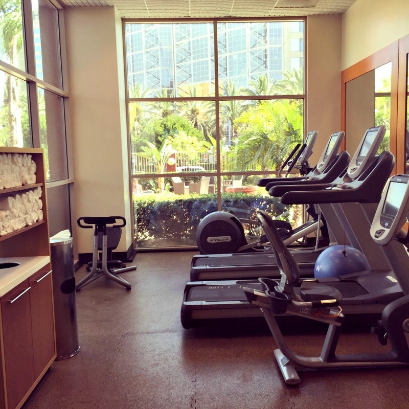 The Embassy Suites Anaheim South fitness center looks out onto the outdoor pool 