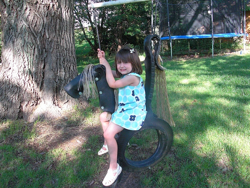 Little girl on tire swing