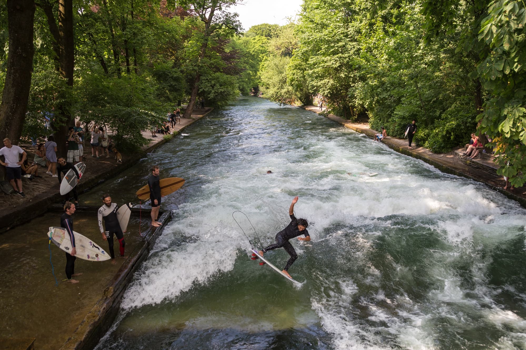 A German surfer hanging ten in the Eisbach River ~ Munich with kids