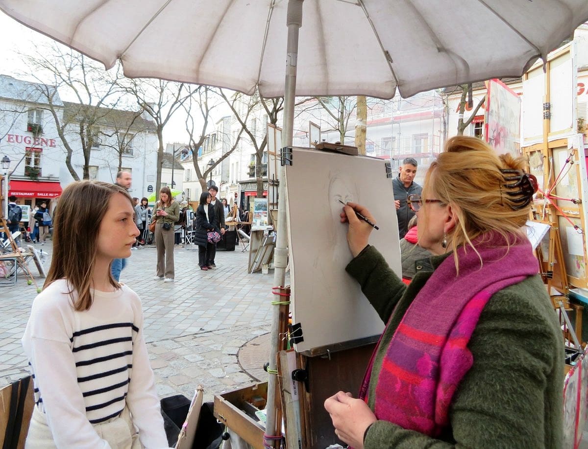 My daughter getting her portrait drawn in Montmartre 