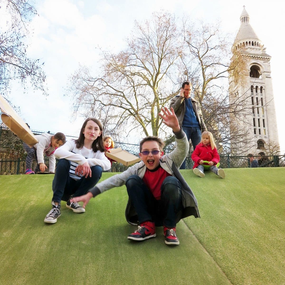 Kids slide down this faux grass hill at Parc de la Turlure atop piece of cardboard or on their feet 