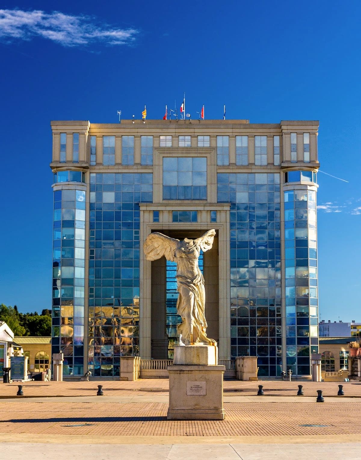 A copy of the Winged Victory of Samothrace sits in front of Montpellier's unusual arch-shaped City Hall 