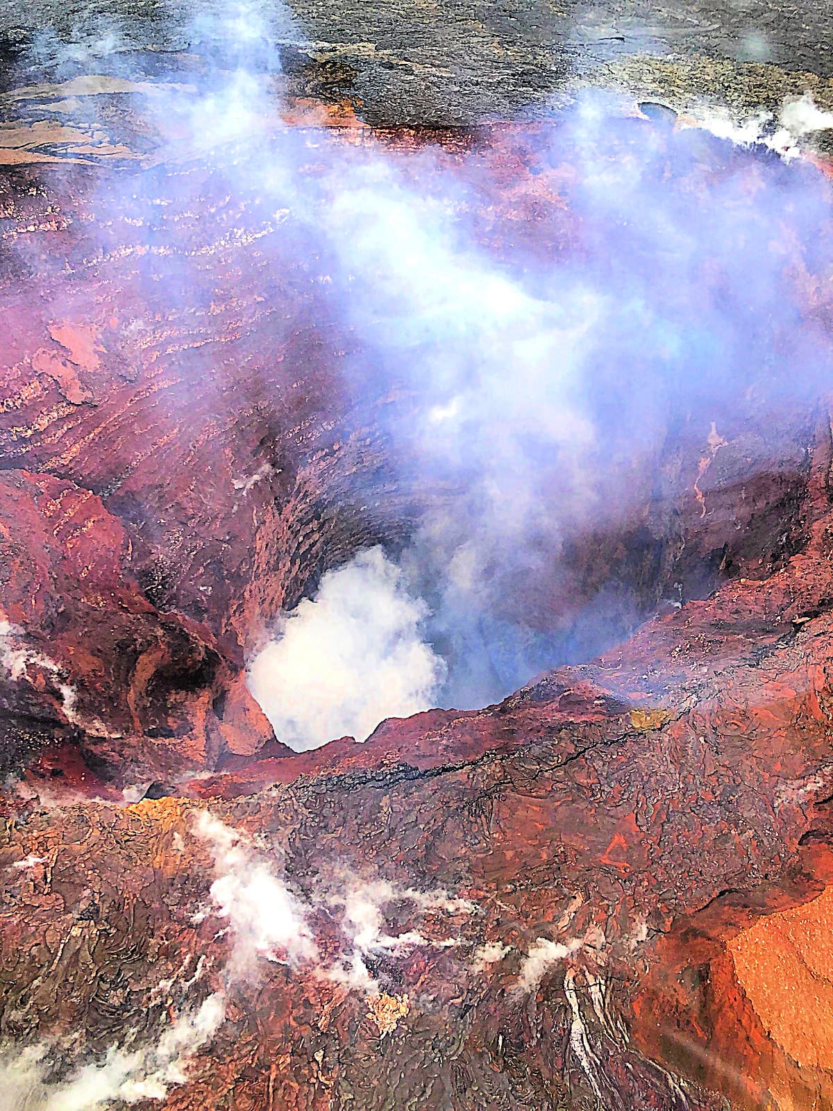 Peering into Pu'u 'O'o from a helicopter tour of Volcanoes National Park with kids