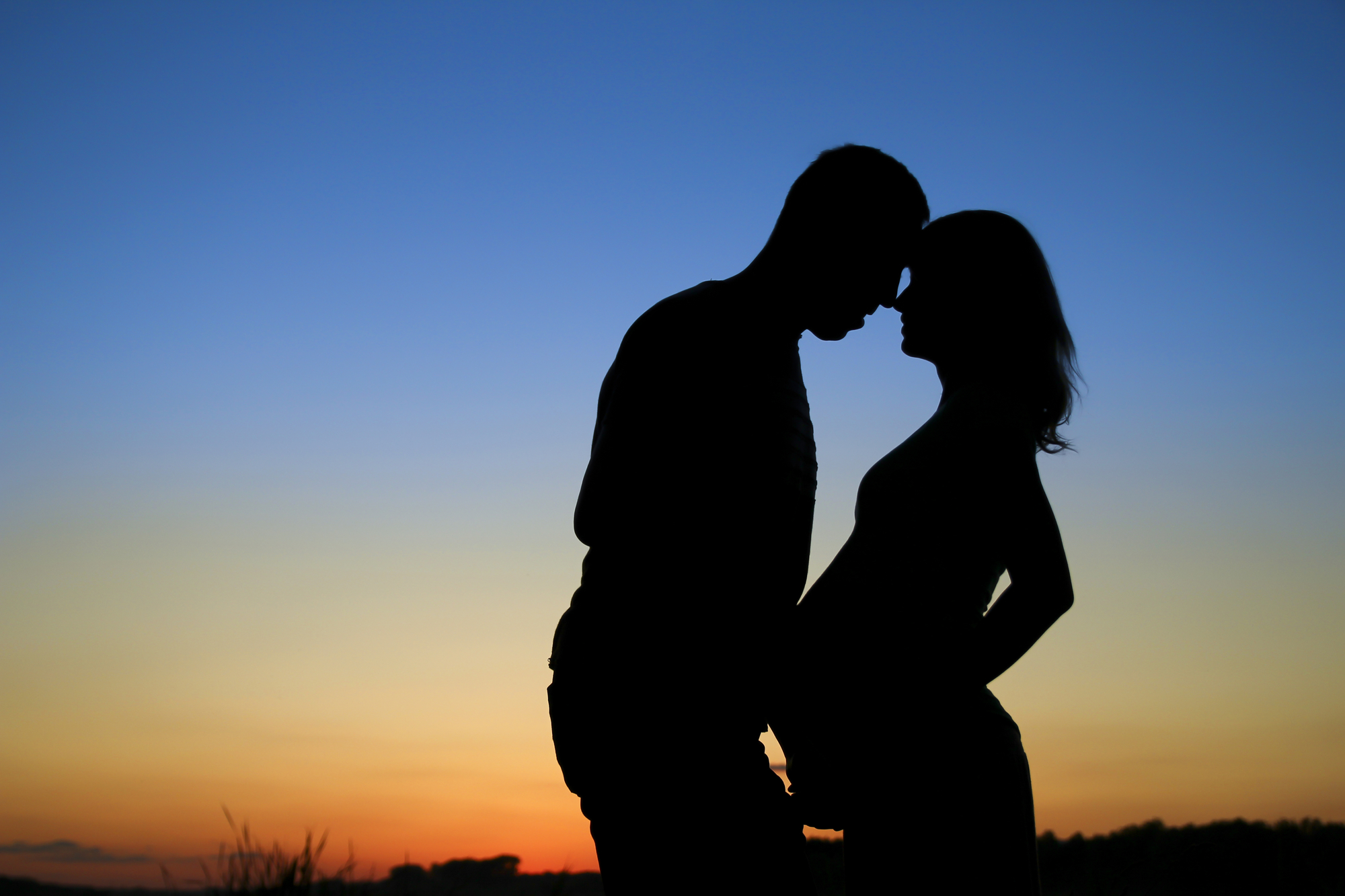 Pregnant couple with beach sunset