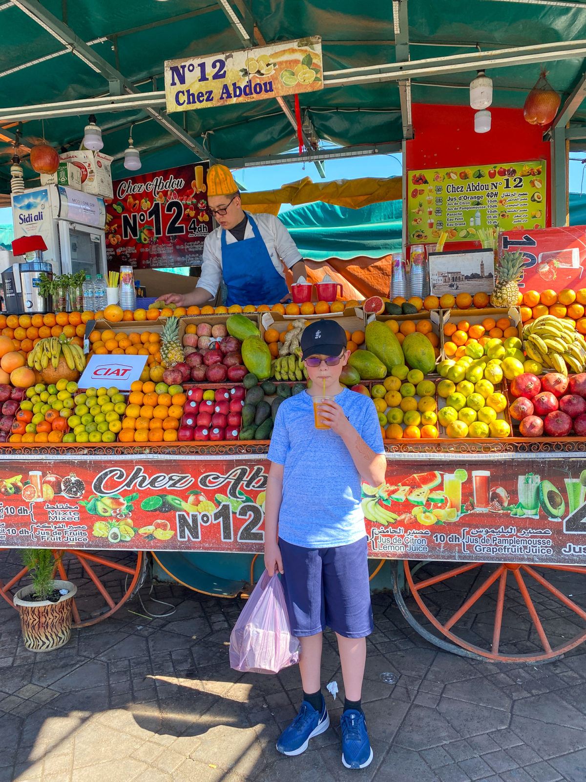 My son drinking orange (tangerine?) juice in the Marrakech medina 