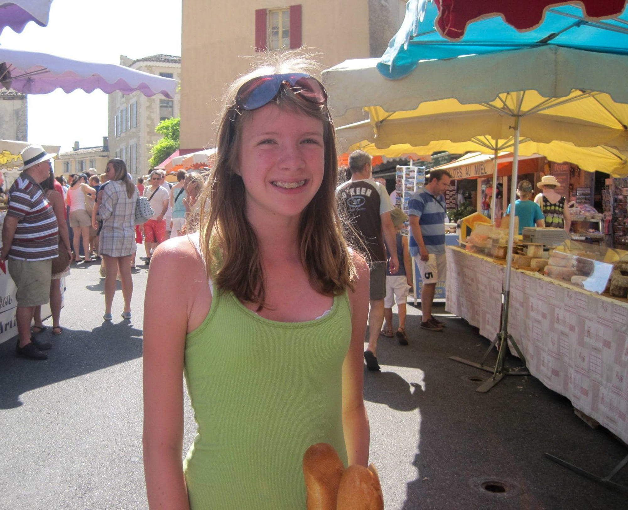 Teen holding a baguette in the market in Gordes, France 