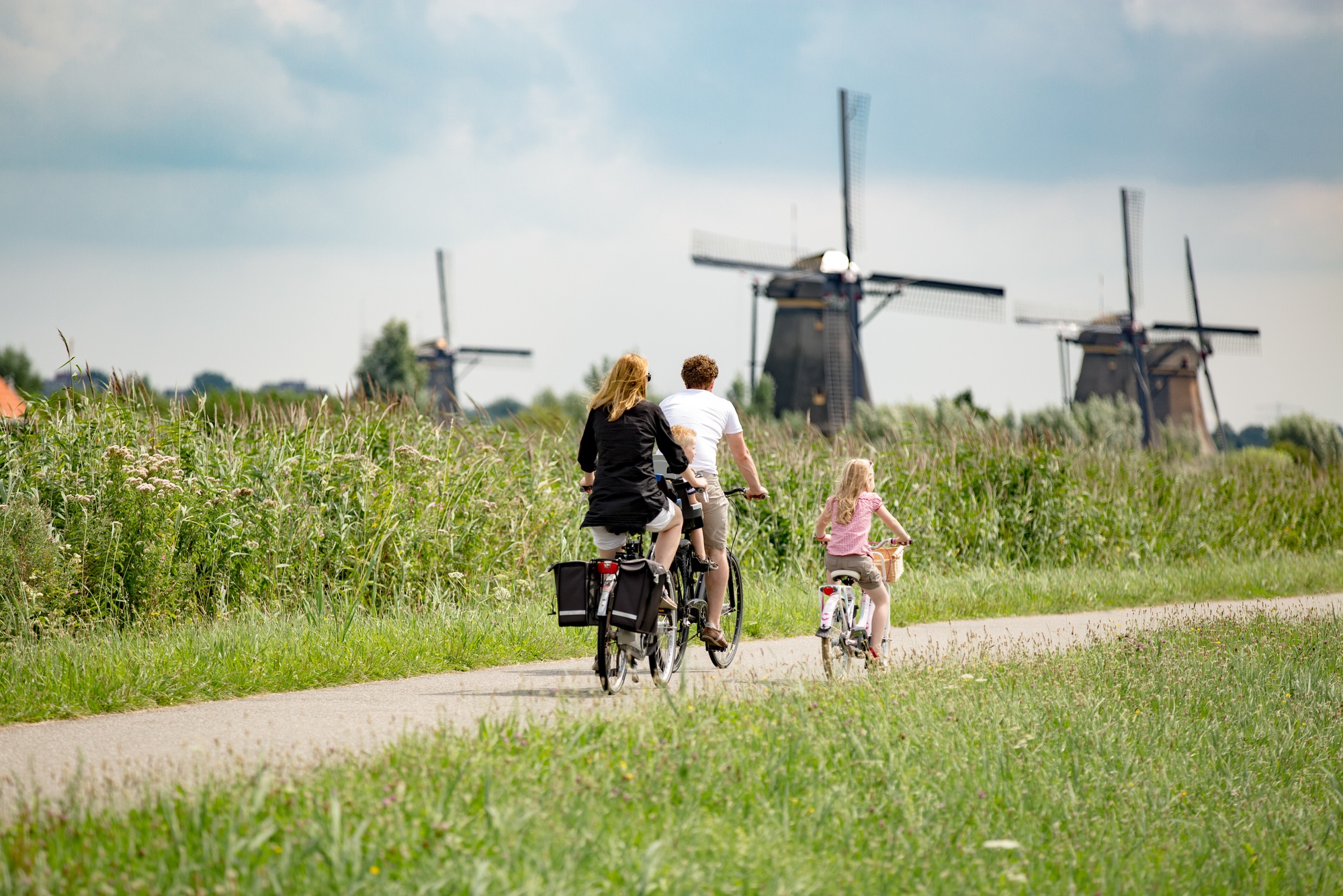 Parents and their child riding bikes near the famous windmills of Kinderdijk in the Netherlands