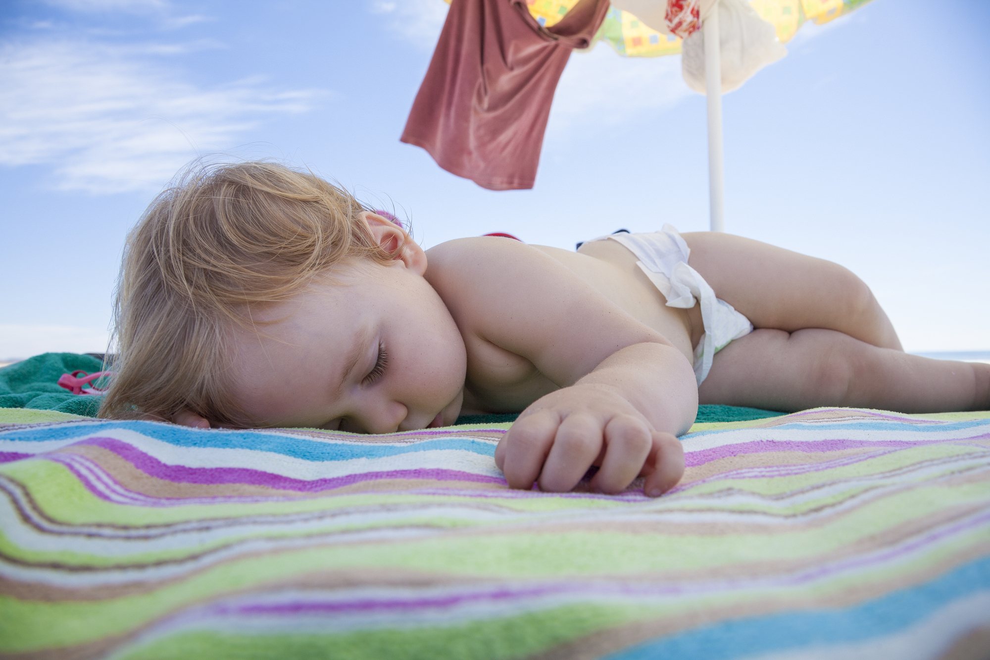 Baby sleeping on beach on vacation