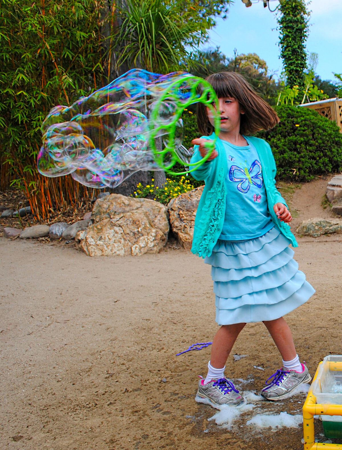 Child making bubbles in the Seeds of Wonder Garden