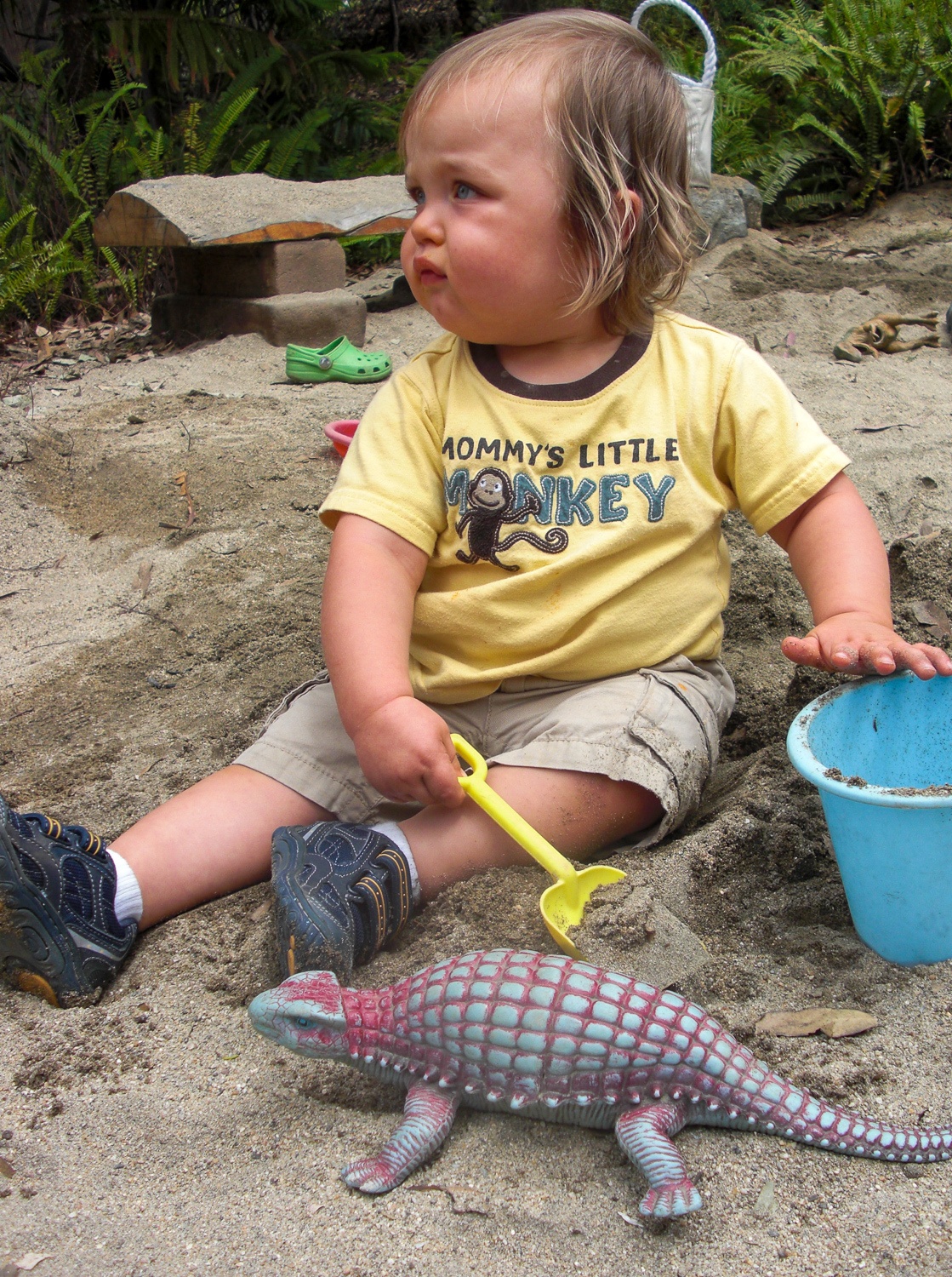 Toddler digging for dinosaurs in the Seeds of Wonder Children's Garden