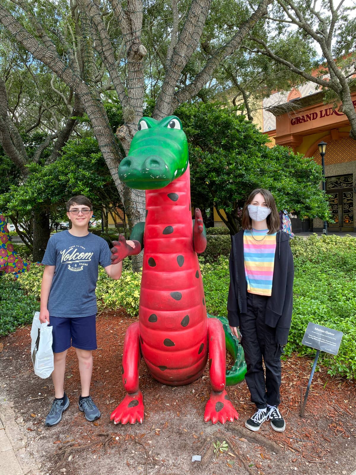 Kids posing with one of the painted alligator statues at Sawgrass Mills in Fort Lauderdale