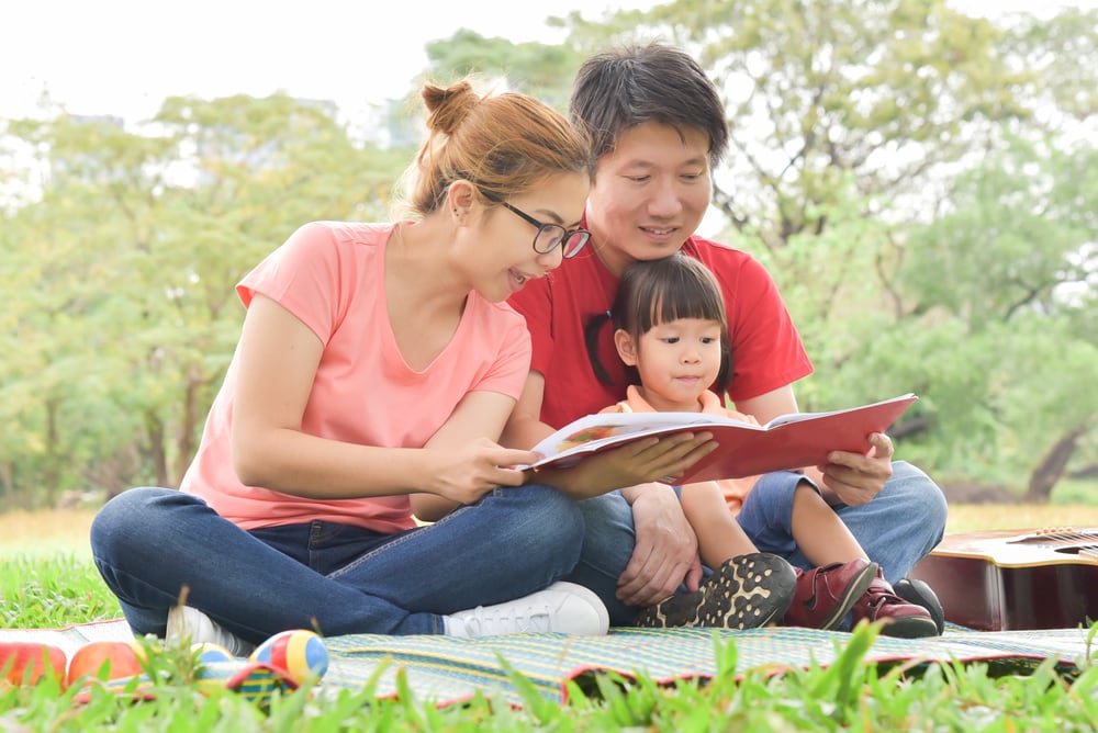 Parents reading a book with their young child