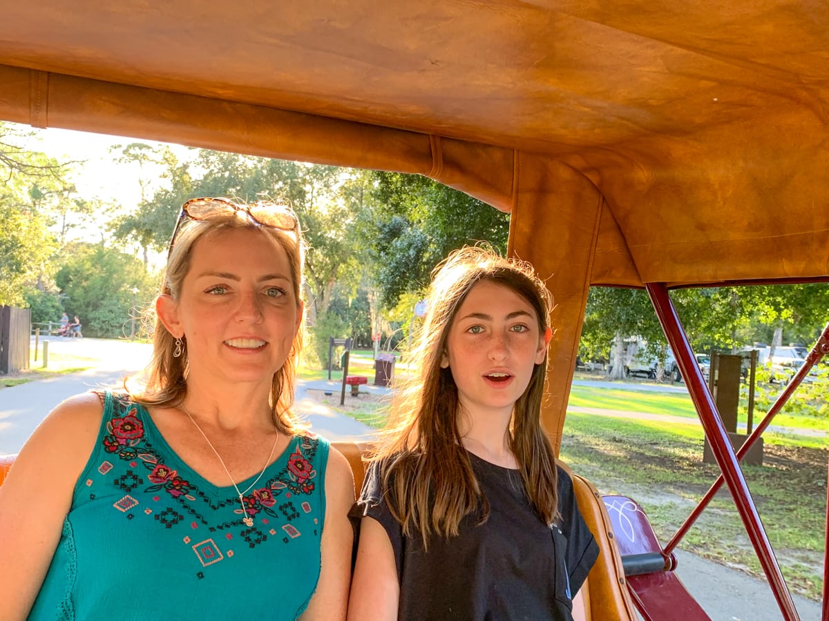 Teen and mom in horse-drawn carriage at Disney's Fort Wilderness