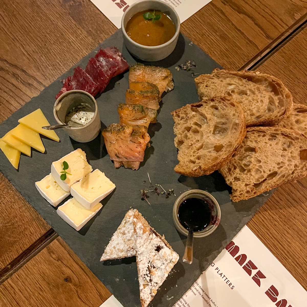 Icelandic charcuterie board at Sky Lagoon's Smakk Bar with cheeses, sourdough bread, smoked salmon, reindeer meat, and blueberry Happy Marriage Cake 