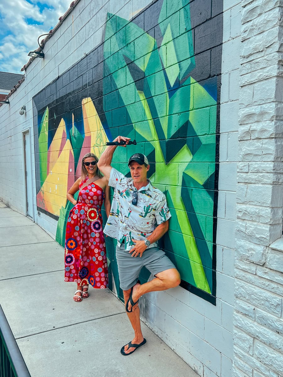 Adults posing with a mural in Cary just outside Raliegh 