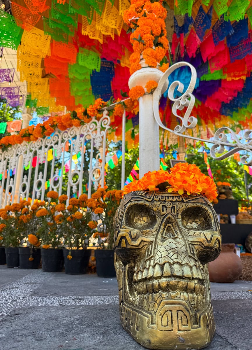 Dia de los Muertos skull, marigolds, and paper banners at Plaza de Armas in Puerto Vallarta's center