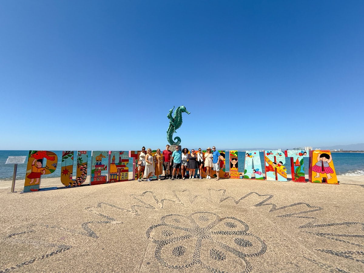 Posing at the Puerto Vallarta sign with friends along the Malecón 