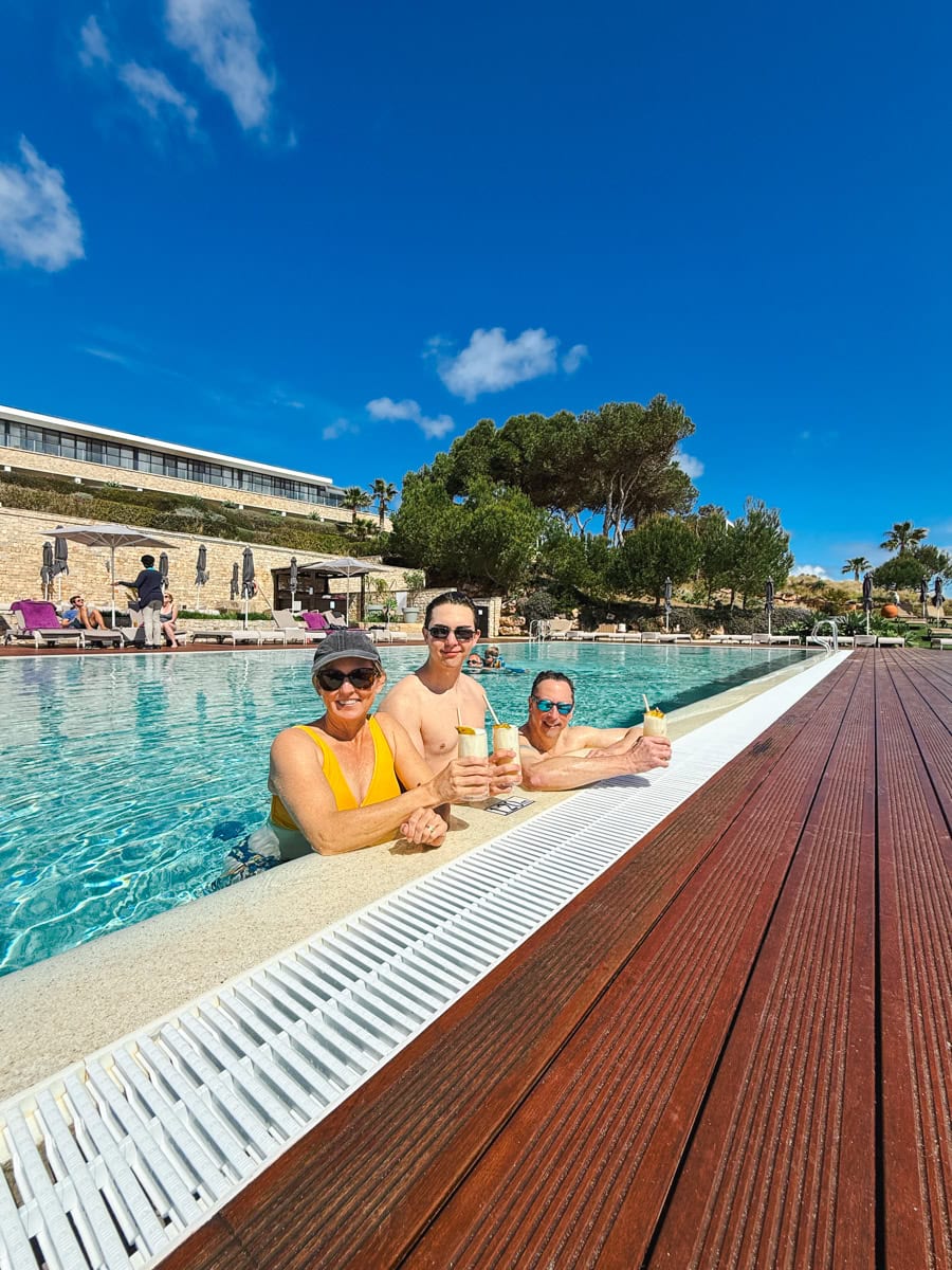Mom, dad, and teenager sipping piña coladas at the Pool Hangout at Martinhal Sagres