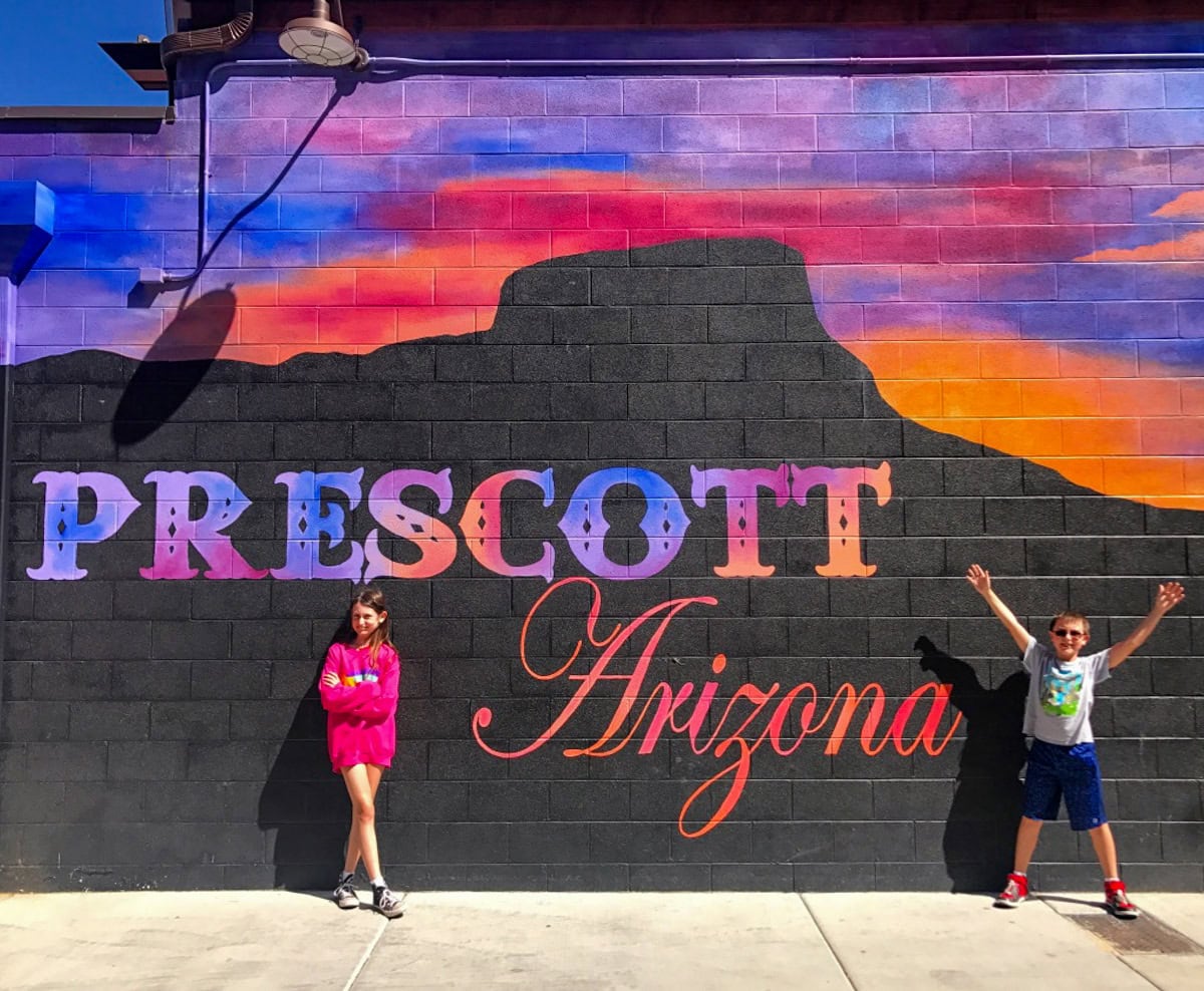 Kids posing in front of the Prescott sunset mural by Dana Cohn
