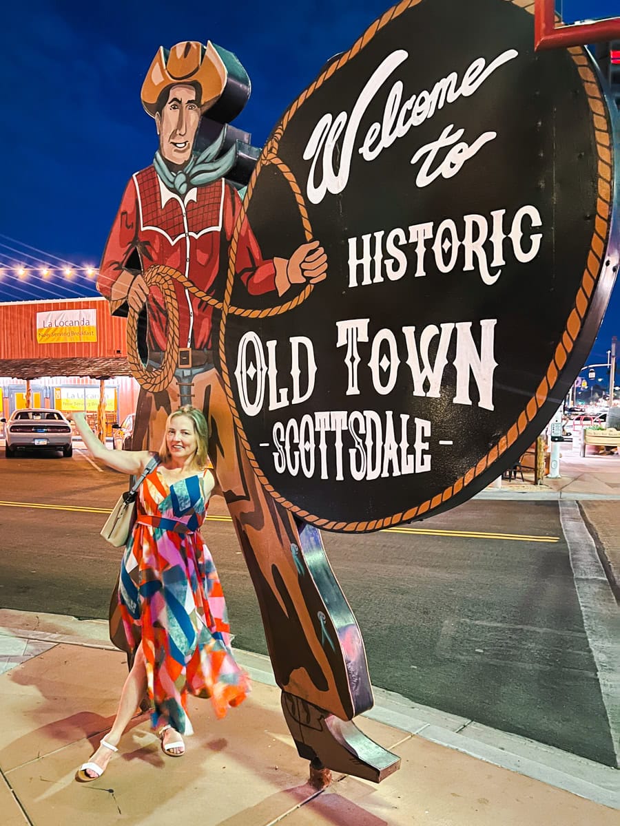 Woman with Old Town Scottsdale sign in the evening